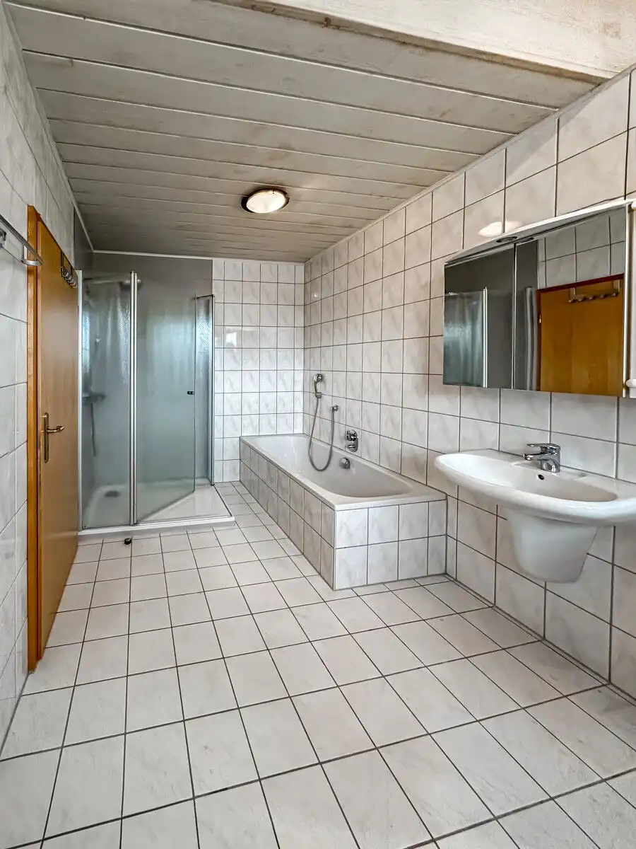 Salle de bains avec baignoire et douche de plain-pied